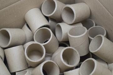 Cardboard spools in bulk in a box. Reels with a diameter of 40 mm for winding paper. Selective focus
