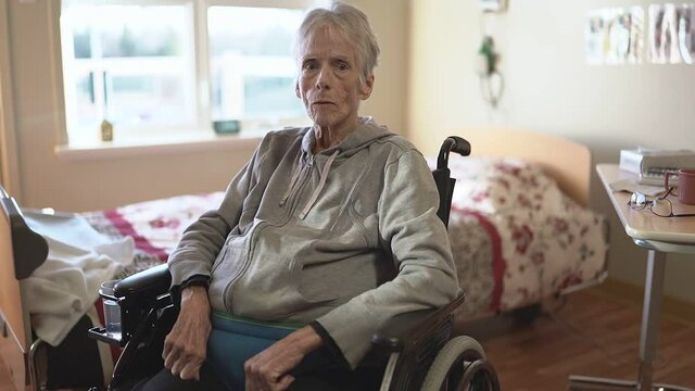 Sick, elderly senior woman in a hospital room with wheel chair