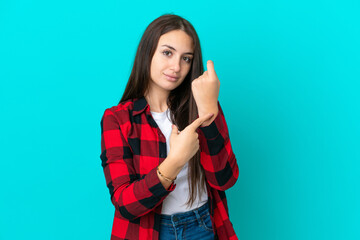 Young Ukrainian woman isolated on blue background making the gesture of being late