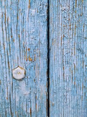 Macro photo of old wooden door of blue color with pin