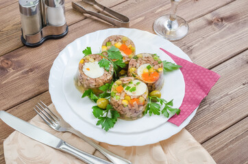 Jellied meat with pieces of meat with vegetables and herbs