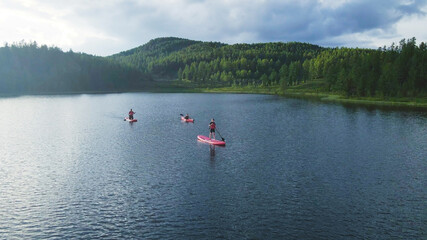 Fototapeta na wymiar People kayaking on the crystal water lake. Aerial footage