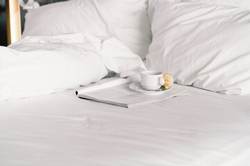 Breakfast on the bed in the hotel room. Breakfast in a snow-white bed, coffee with a croissant. Cozy morning. Breakfast in bed.