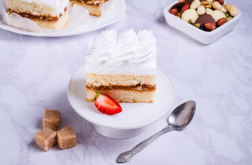 Sponge cake with protein cream on white plate