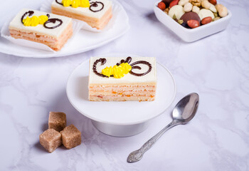 Sponge cake with cream and frosting on white plate