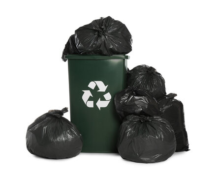 Dark green recycling bin overfilled with garbage bags on white background