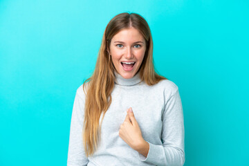 Young blonde woman isolated on blue background with surprise facial expression