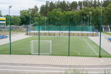 Fototapeta premium Green soccer field with blue seats. Sports stadium.