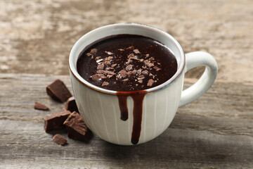 Yummy hot chocolate in cup on wooden table