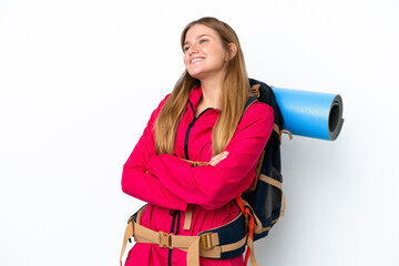 Young mountaineer girl with a big backpack over isolated white background happy and smiling