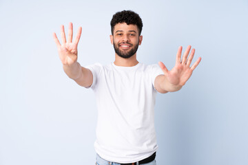 Young Moroccan man isolated on blue background counting nine with fingers