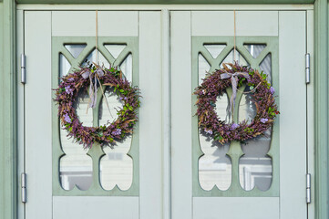 Wreath made from heather and other forest herbs with ribbon on door of house. Ancient Celtic...
