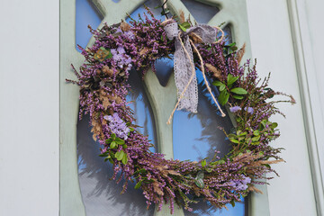 Wreath made from heather and other forest herbs with ribbon on door of house. Ancient Celtic...