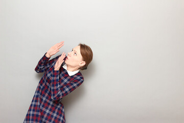 Portrait of frightened woman raising hands up to protect herself