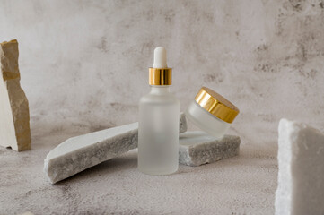 Non-binary unisex cosmetic set mockup. Matte Glass dropper bottles jar with a pipette for imprint branding copy space with marble background. Organic Spa Cosmetics