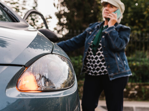 Senior Woman Calling Service Standing Near Broken Car