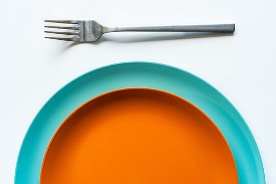 Two colored plates placed on each other on white table
