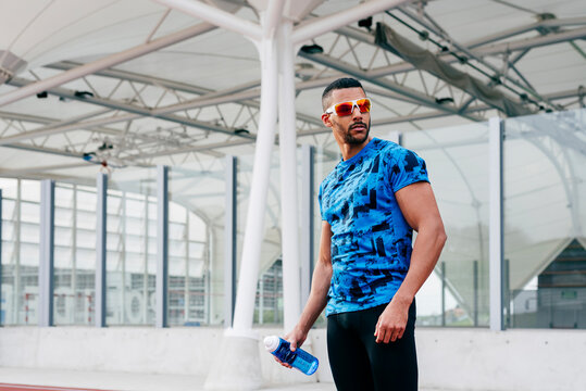 Athletic man standing on the running track