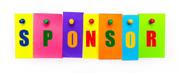 On a white background, buttons are used to fix bright multi-colored strips of paper with the text SPONSOR
