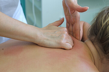 Woman professional masseur shows massage techniques. Back massage for the purpose of healing, muscle relaxation and treatment.