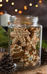 Christmas cookies in a glass jar, pine cones and a garland.