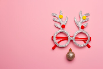 Christmas composition of glasses with reindeer antlers on a pink background