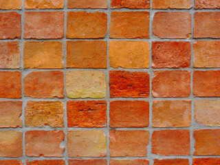 textured light brown and yellow brick wall closeup. gray mortar joint. rough clay texture. running bond pattern. construction industry and architecture concept. wallpaper and graphic resources
