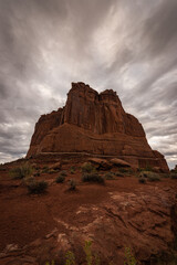Fototapeta premium Courthouse rock formation in Arches National Park under moody dramatic sky weather, Utah