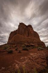 Courthouse rock formation in Arches National Park under moody dramatic sky weather, Utah