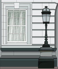 The facade of the building with a window and a street lamp in the classicism style.