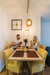 A young couple has breakfast at home