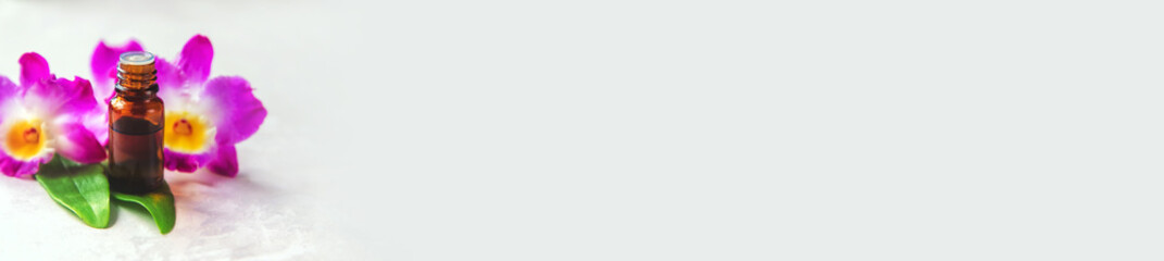 Orchid essential oil in a small bottle. Selective focus.