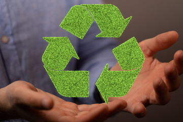 hand holding green recycle symbol