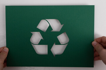 hand holding green recycle symbol