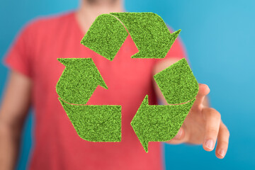 hand holding green recycle symbol