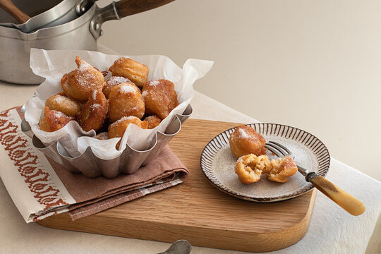 Deep fried beignets doughnut placed on wooden tray