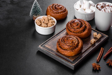 Freshly baked cinnamon roll with spices and cocoa filling on a black background