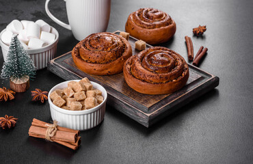 Freshly baked cinnamon roll with spices and cocoa filling on a black background