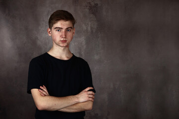 Portrait of a Handsome teenage boy on a gray background. Copy place for text