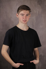 Portrait of a Handsome teenage boy on a gray background