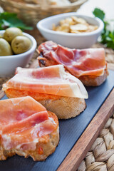 Spanish cuisine tapas with Serrano Ham and tomatoes - montadito de tomate y jamon serrano.