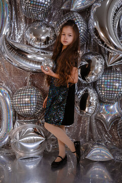 cute little child girl in black dress on confetti background