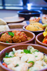 Tapas buffet with traditional Spanish cuisine dishes - Gambas, fish Crocuetes, Octopus, Chorizo Sausage and Serrano Ham.