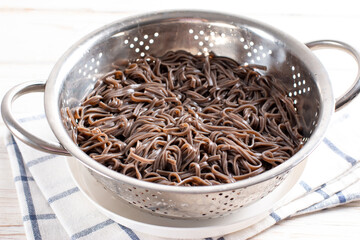 Buckwheat soba noodles in a sieve. Preparation Japanese dish buckwheat noodles with vegetables and meat. Step by step