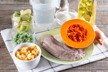 Preparation stewed beef tongue with vegetables close-up in a saucepan on the table. Step by step