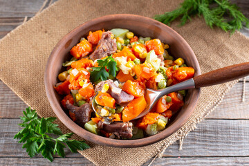 Stewed beef tongue with vegetables in a bowl on the table. horizontal