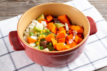 Stewed beef tongue with vegetables in a saucepan on the table. horizontal