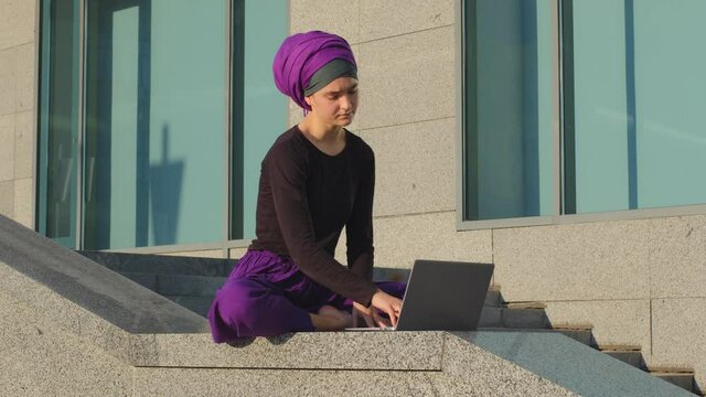 Tired worried overworked islamic girl muslim student business woman sit in city working studying at laptop feels angry turns off computer sits in lotus position meditating feeling calm meditation