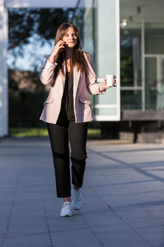 A young girl is walking while talking on her mobile phone