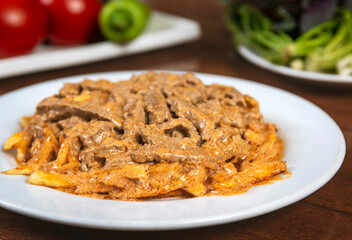 Beef Stroganoff traditional Russian dish of beef in sauce, served with fried potatoes.